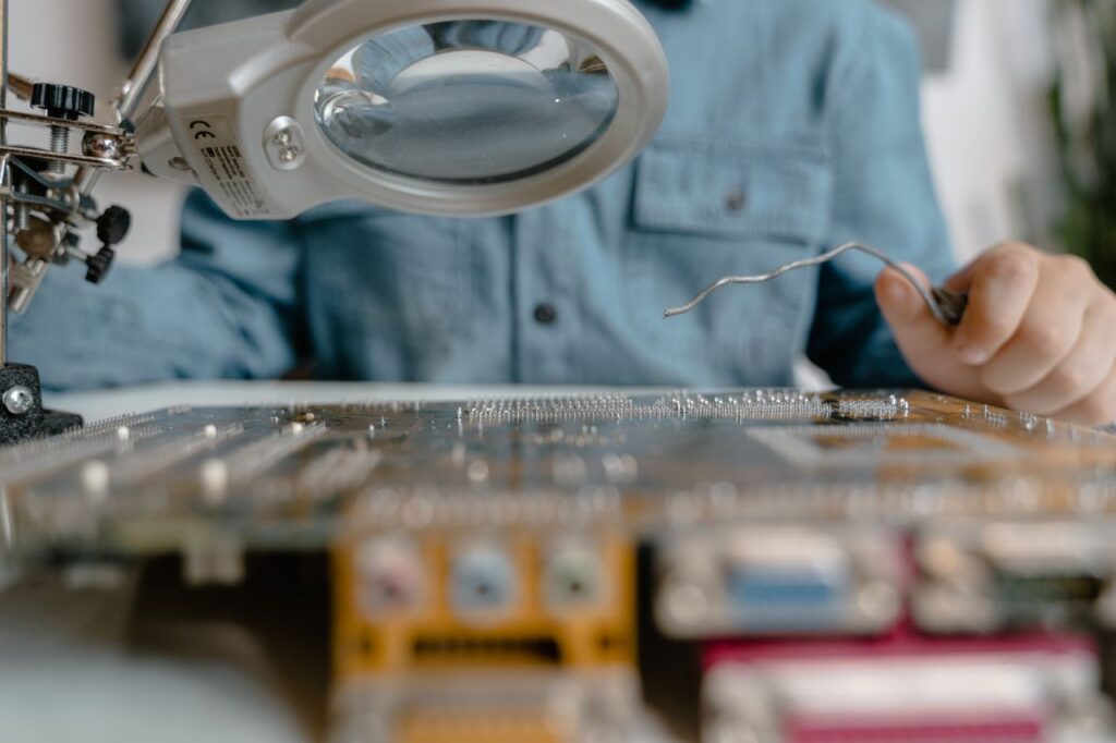 Crafting Captivating Headlines: Your awesome post title goes here A detailed view of electronic circuit inspection using a magnifying glass and tools.