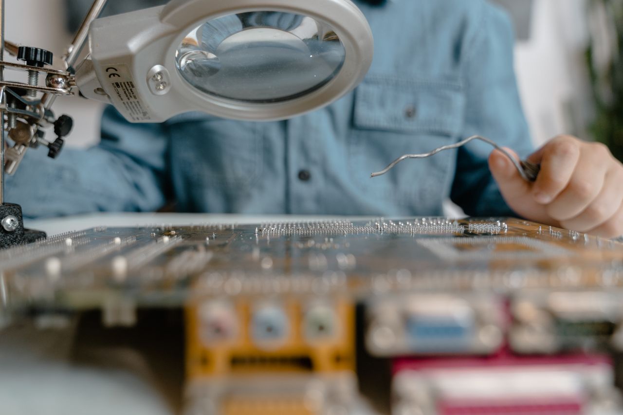 Crafting Captivating Headlines: Your awesome post title goes here A detailed view of electronic circuit inspection using a magnifying glass and tools.